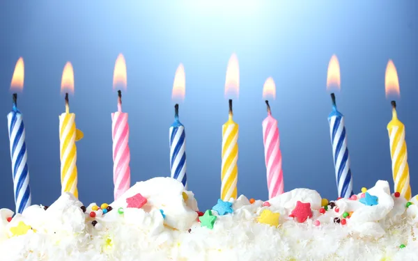 Hermosas velas de cumpleaños sobre fondo azul —  Fotos de Stock