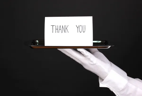 Gümüş tepsi üzerinde siyah izole kart söyleyerek teşekkür ederiz elinde eldiven el — Stok fotoğraf