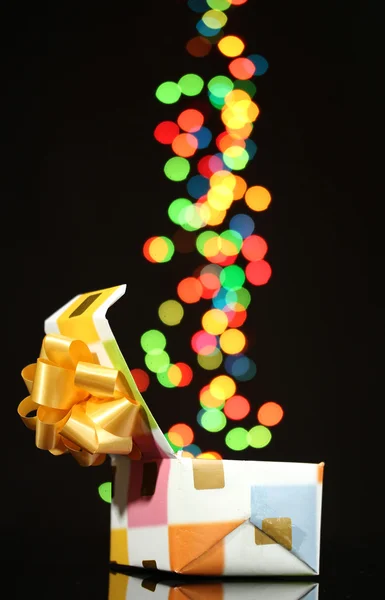 Öppna presentförpackning med bokeh bakgrund på svart — Stockfoto