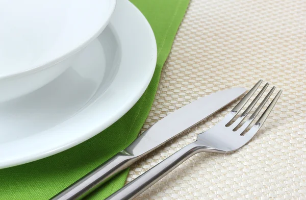 Налаштування столу з виделкою, ножем, тарілками та серветкою — стокове фото