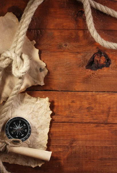 Старий папір, компас і мотузка на дерев'яному столі — стокове фото