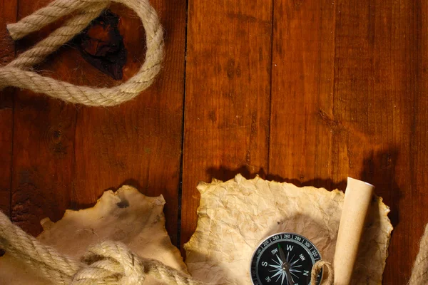 Старая бумага, компас и веревка на деревянном столе — стоковое фото