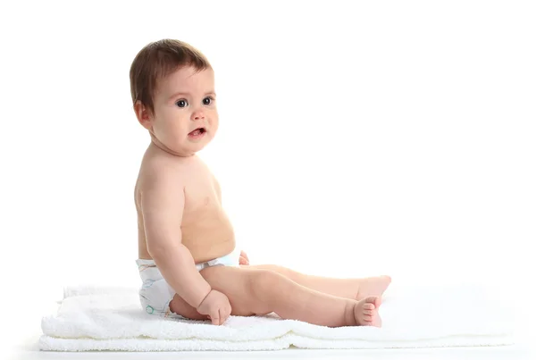 Söt baby flicka sitter på handduk isolerad på vit — Stockfoto