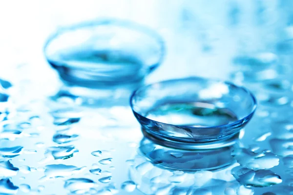 Contactlens met druppels op blauwe achtergrond — Stockfoto