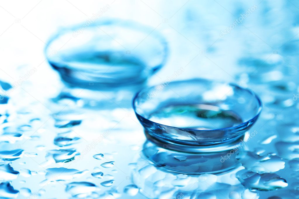Contact lens with drops on blue background
