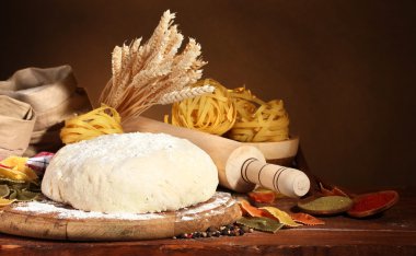 Ingredients for homemade pasta on wooden table on brown background clipart