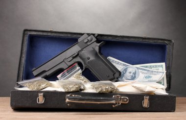 Kokain, esrar dolar ve gri arka plan üzerinde ahşap masa durumunda tabanca