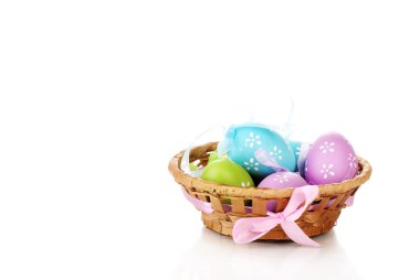 Colorful easter eggs in basket isolated on white clipart