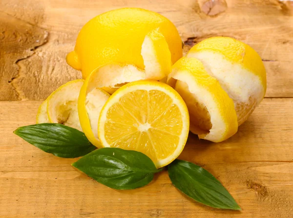 Rijp citroenen met bladeren op houten tafel — Stockfoto