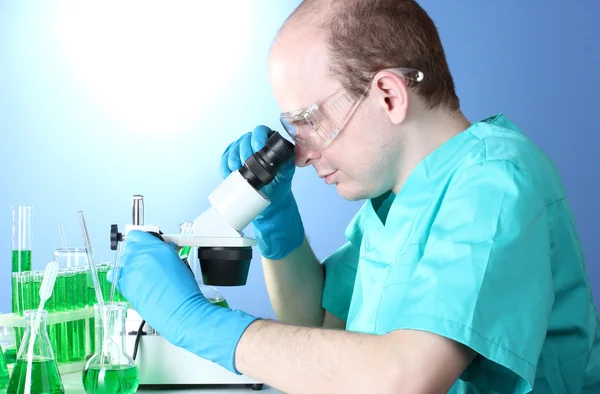 Вчений дивиться на мікроскоп в хімічній лабораторії — стокове фото