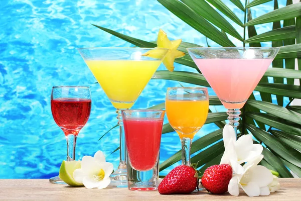 Exotische cocktails en bloemen op tafel op blauwe zee achtergrond — Stockfoto