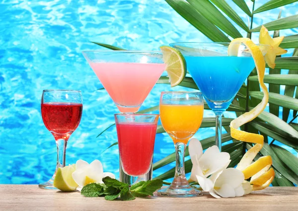 Экзотические коктейли и цветы на синем фоне — стоковое фото
