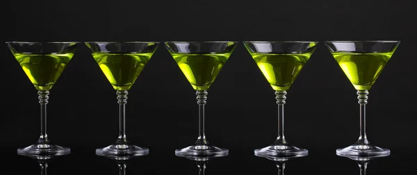Coquetel amarelo em copos de martini isolados em preto — Fotografia de Stock