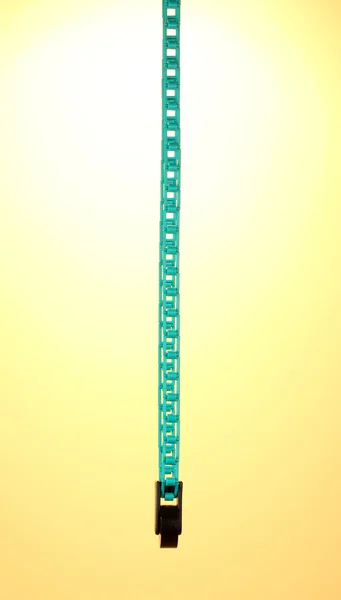 Lifting chain for studio background on yellow background — Stock Photo, Image