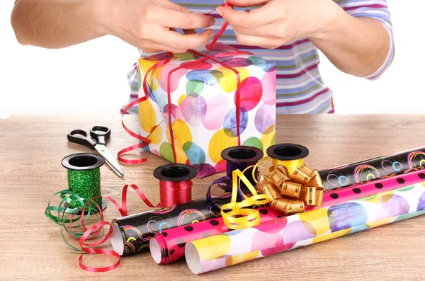 Envolver regalos rodeados de papel, cinta y arcos —  Fotos de Stock