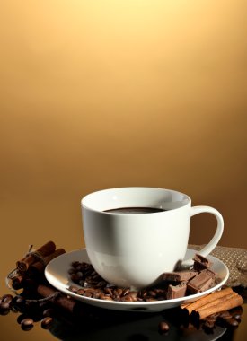 fincan kahve ve fasulye, tarçın ve çikolata kahverengi zemin üzerinde