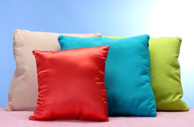 Bright pillows on blue background clipart