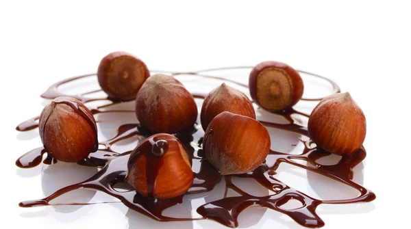 Вкусный фундук и шоколадный сироп изолированы на белом — стоковое фото