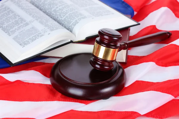 Soudce kladívkem a knihy na pozadí americké vlajky — Stock fotografie