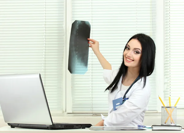 Bella ragazza medico tenendo raggi X in ufficio — Foto Stock