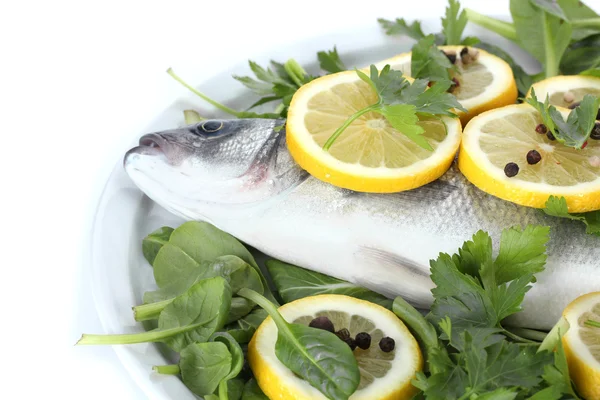 Pescado fresco con limón, perejil y especias en plato aislado sobre blanco —  Fotos de Stock