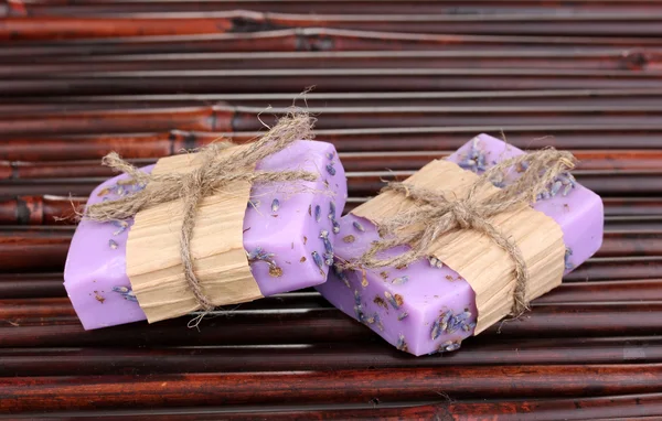 Sabonetes de lavanda feitos à mão em esteira de bambu — Fotografia de Stock