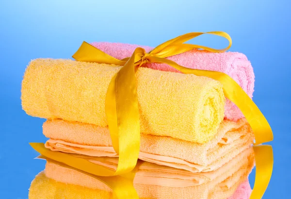 Kleurrijke handdoeken met lint op blauwe achtergrond — Stockfoto
