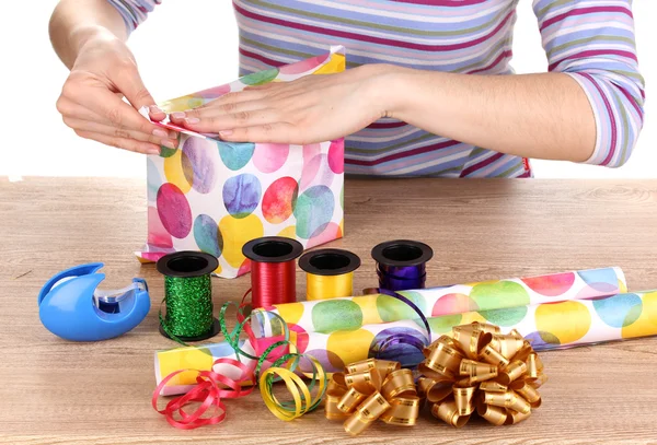 Wrapping presents surrounded by paper, ribbon and bows — Stock Photo, Image