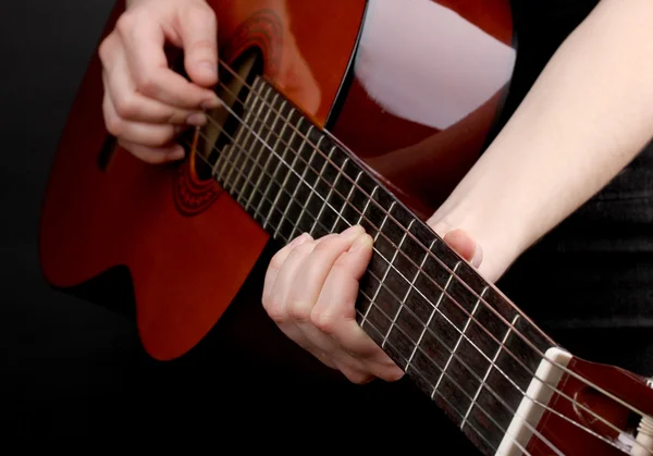 Kytara v rukou izolovaných na černém — Stock fotografie
