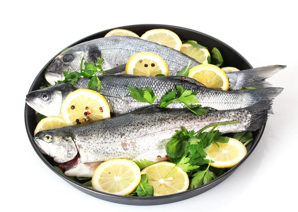 Fresh fishes with lemon, parsley and pepper on plate isolated on white — Stock Photo, Image