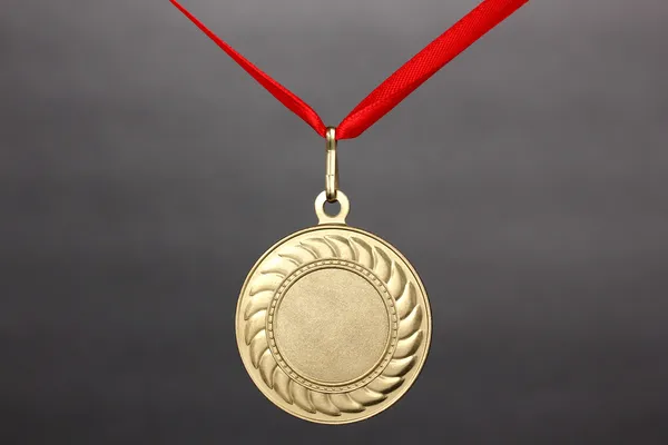 Gold medal on grey background — Stock Photo, Image