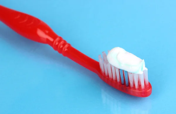 Cepillo de dientes con pasta sobre fondo azul —  Fotos de Stock