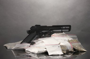 Cocaine and marihuana in packages and handgun on grey background clipart