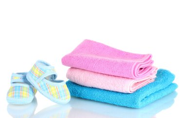 Blue baby booties and three colorful towels isolated on white