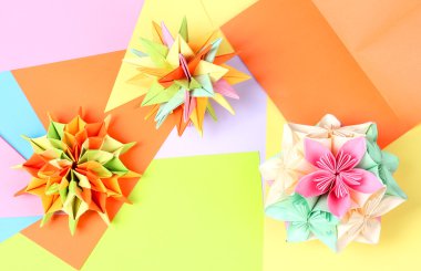 Colorfull origami kusudamas on bright paper background clipart