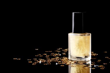 Golden nail polish on black background clipart
