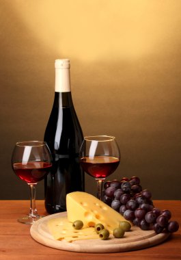 kadehlerin ve peynirle kahverengi zemin üzerine ahşap masa üzerinde büyük şarap şişesi