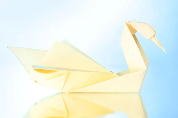Origami papper svan på blå bakgrund — Stockfoto