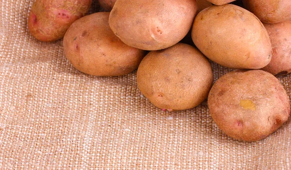 Patatas frescas en primer plano arpillera — Foto de Stock