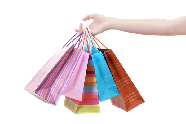 Mano femenina sosteniendo bolsas de compras brillantes aisladas en blanco —  Fotos de Stock