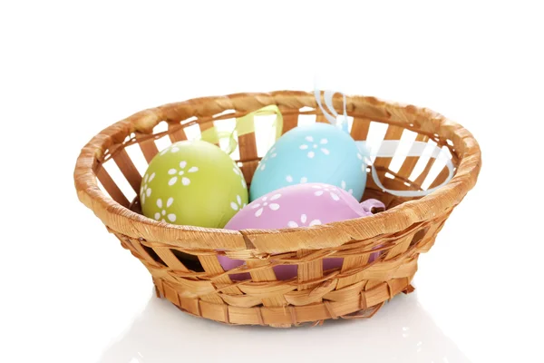 Ovos de páscoa coloridos em cesta isolados em branco — Fotografia de Stock