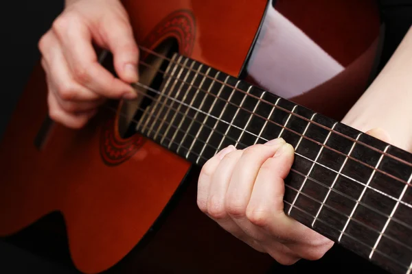 Guitar in hands isolated on black — Stock Photo, Image