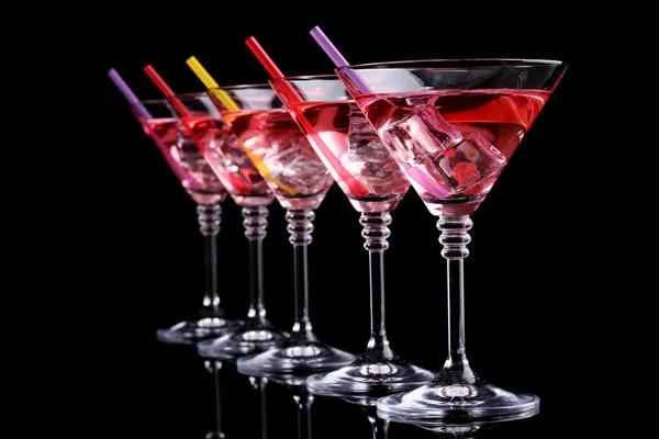 Красный коктейль в бокалах мартини, изолированных на черном — стоковое фото