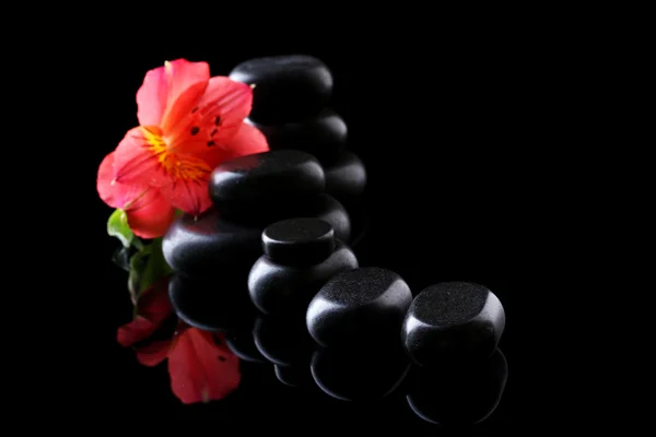 スパの石と黒の背景に赤い花 — ストック写真