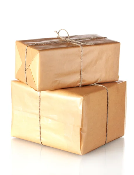 Dos paquetes envueltos en papel marrón atados con cordel dispuestos en una pila aislada en blanco — Foto de Stock