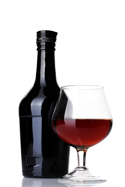 Glas brandy en fles geïsoleerd op wit — Stockfoto