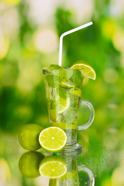 Bicchiere di cocktail con lime e menta su fondo verde — Foto Stock
