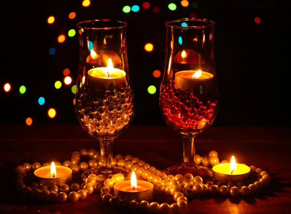 Incredibile composizione di candele e bicchieri su tavolo di legno su sfondo luminoso — Foto Stock