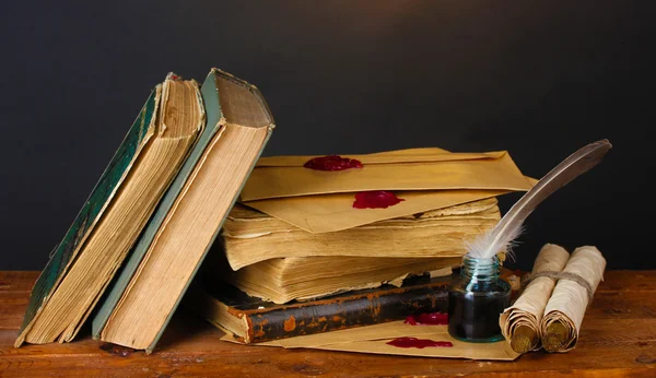 Libros antiguos, pergaminos, pluma y tintero sobre mesa de madera sobre fondo marrón —  Fotos de Stock