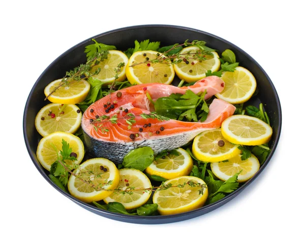 Красная рыба с лимоном, петрушкой и перцем на тарелке изолированы на белом — стоковое фото
